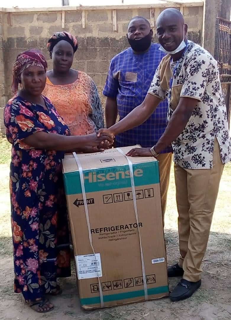 Foundation team and a widow exchange a handshake over a livelihood gift