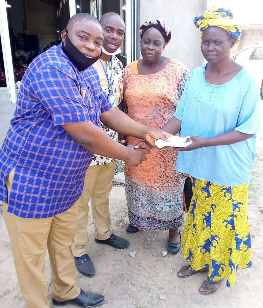 Foundation member handing an envelope of support to a widow
