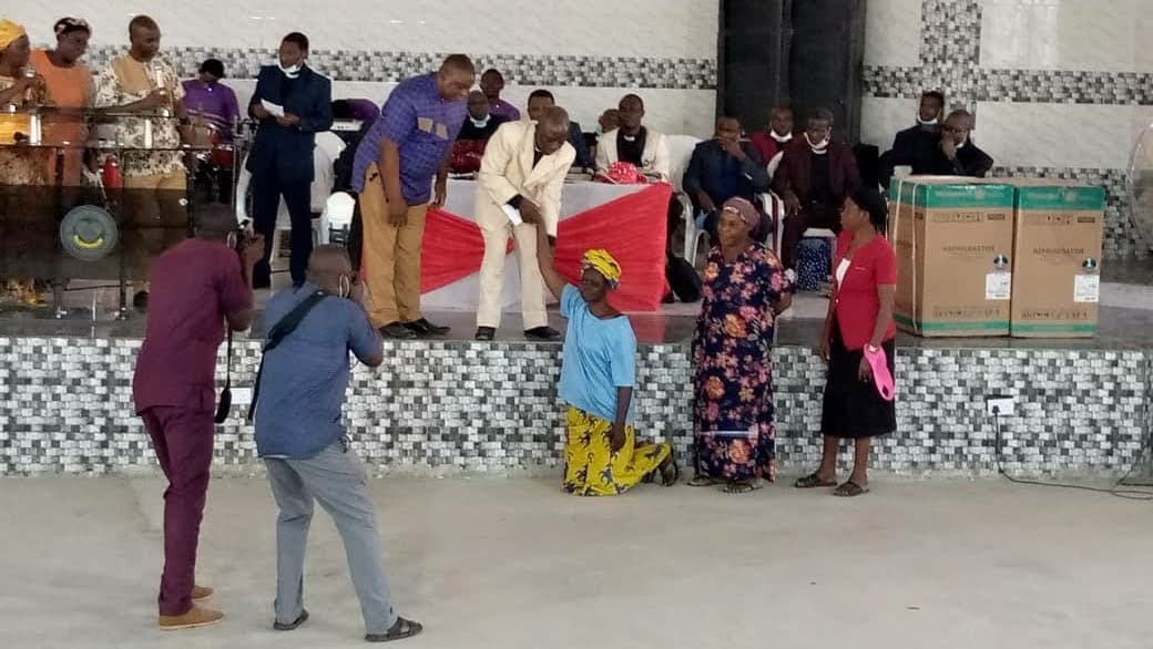 Widows kneel at the altar as gifts are presented during the gathering